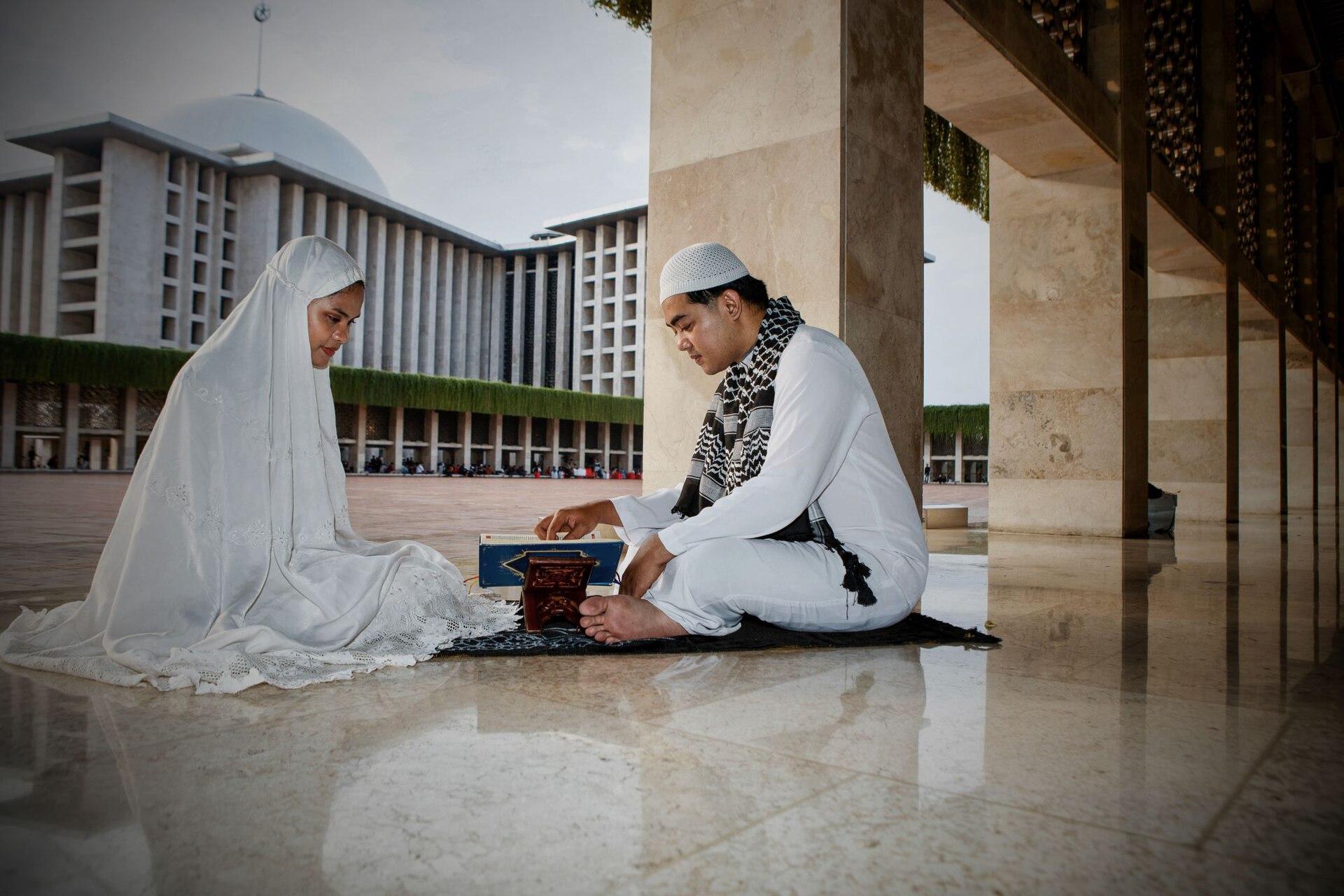 A couple reading the Quran together at the mosque